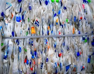 paquet en plastique bleu et jaune sur une clôture en bois blanche