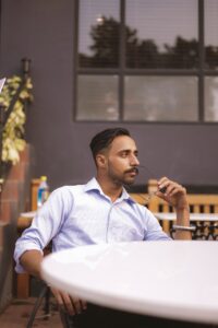 un homme assis à une table avec une fourchette dans la bouche
