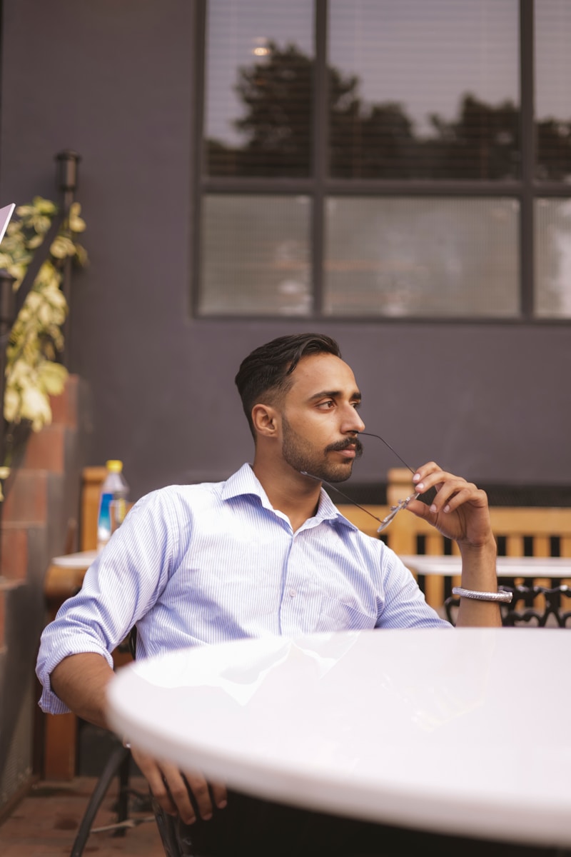 un homme assis à une table avec une fourchette dans la bouche
