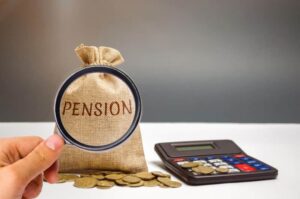 Une main tenant une loupe devant un sac en tissu estampillé du mot « Pension », posé à côté d'une calculatrice et de pièces de monnaie, illustrant les démarches liées à une pension alimentaire impayée.