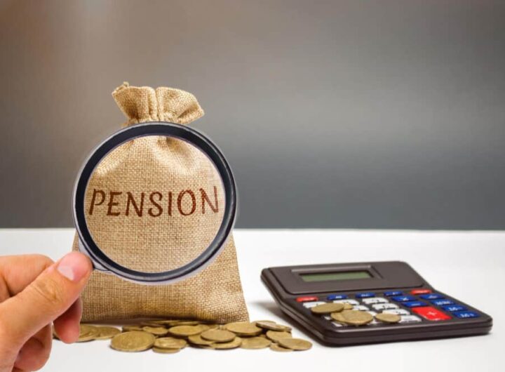 Une main tenant une loupe devant un sac en tissu estampillé du mot « Pension », posé à côté d'une calculatrice et de pièces de monnaie, illustrant les démarches liées à une pension alimentaire impayée.