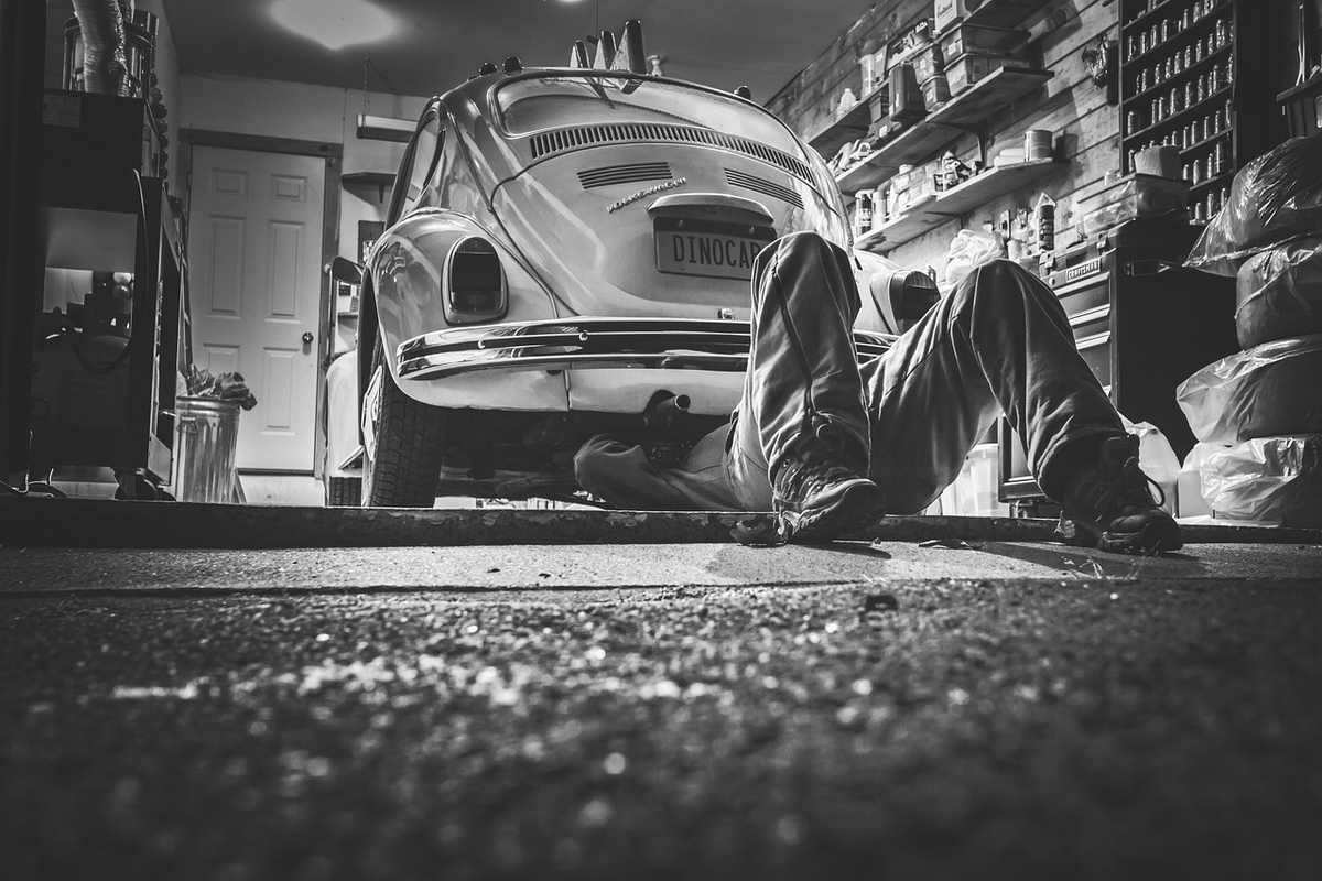 Mécanicien travaillant sous une Volkswagen Coccinelle dans un atelier automobile Mécanicien travaillant sous une Volkswagen Coccinelle dans un atelier automobile