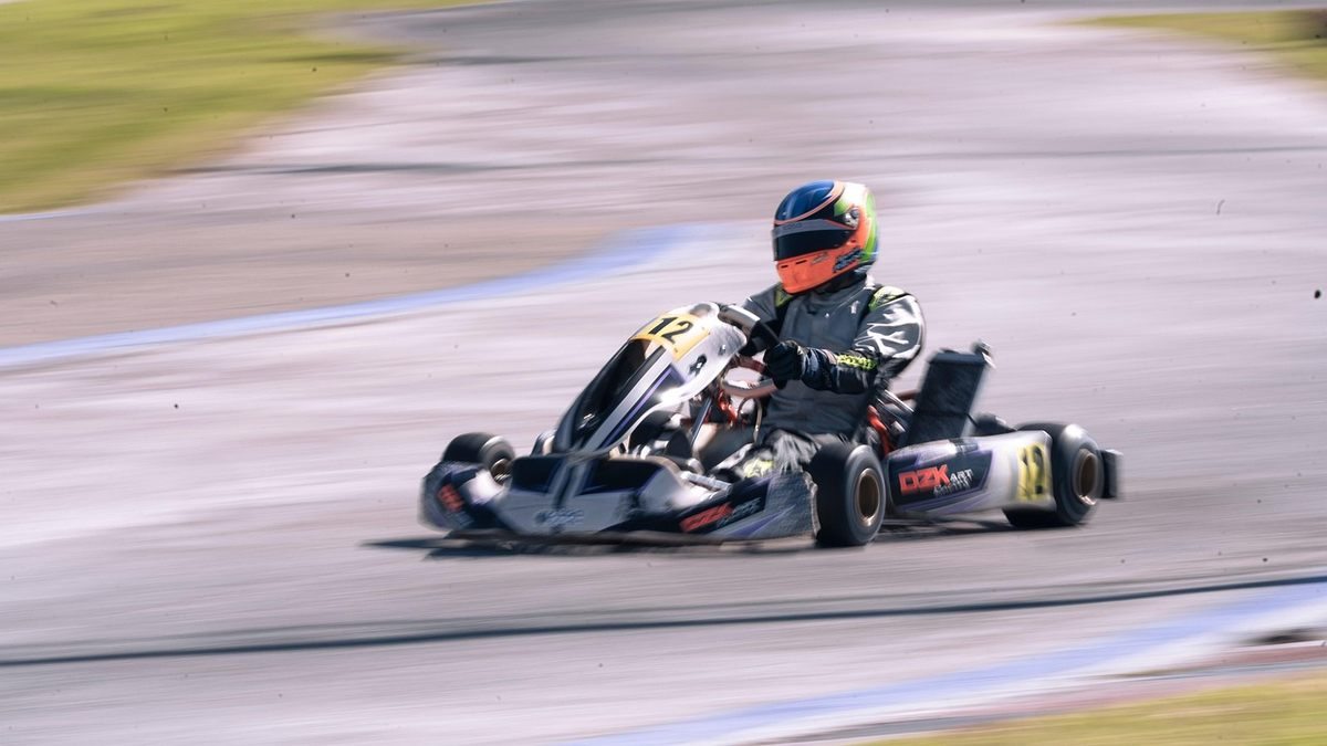 Un pilote en kart de course sur circuit, vitesse ressentie