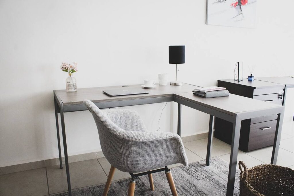 Bureau d'angle, chaise, lampe, vase, ordinateur, tapis, panier