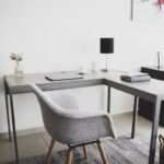 Bureau d'angle, chaise, lampe, vase, ordinateur, tapis, panier